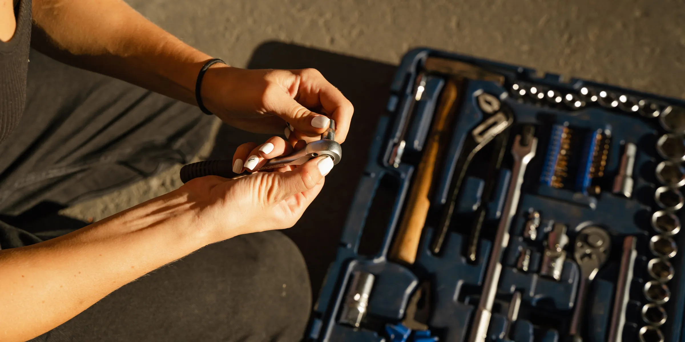 Hands taking a tool from an open toolset